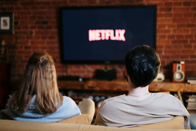 Woman And Man Sitting on A Couch Watching Netflix